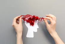 Stres uničuje zmožnost tvorjenja spomina Tangled red threads on the silhouette of the head, representing the brain. Blue background. Flat lay. The concept of mental health and demension