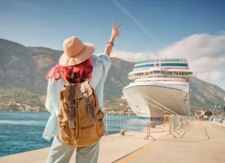 Nasveti, s katerimi boste na križarki ostali zdravi in uživali na dopustu Tourist wearing backpack and hat gesturing near cruise ship at Kotor bay, Montenegro
