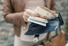 Na tisoče študentov izginilo brez vračila šolnin: »Študentom iz tujine sploh ne bi smeli omogočiti dostopa do teh posojil« Woman holding in hands wallet with euro money. City girl is taking out money from wallet