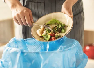 Češka, Danska in Izrael: tako so se s problemom zavržene hrane spopadle te države Woman scraping leftover food from plate into trash bin in kitchen