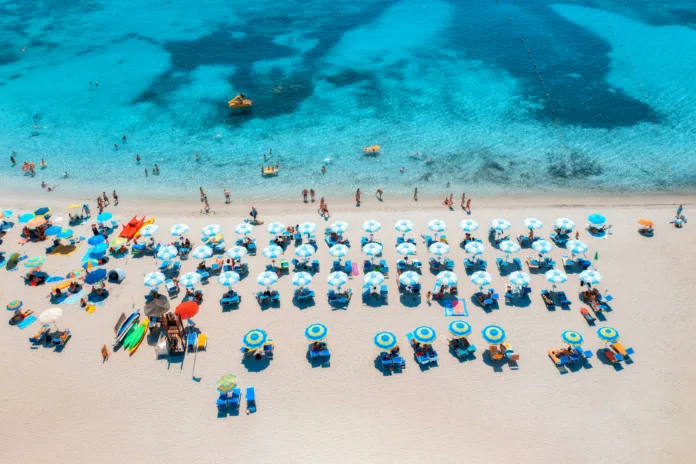 aerial-view-of-colorful-umbrellas-on-sandy-beach-swimming-people-in-blue-sea-at-summer-sunny-day-sardinia-italy-tropical-seascape-travel-and-vacation-top-drone-view-of-ocean-with-azure-water-stockpack-istock Aerial view of colorful umbrellas on sandy beach, swimming people in blue sea at summer sunny day. Sardinia, Italy. Tropical seascape. Travel and vacation. Top drone view of ocean with azure water
