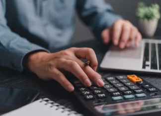 Investiranje za študente: Kako pametno začeti z 20 evri na mesec? Businessman using calculator bookkeeping payroll and budget tax. Business document finance accounting investment