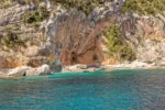 Cala dei Gabbiani, a narrow sandy beach below high limestone cliffs, Gulf of Orosei, Gennargentu National Park, Baunei, Sardinia, Italy, 20th May 2019