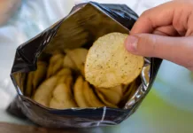 Iz treh sestavin nastane prigrizek, ki je obnorel internet Crispy potato chips in aluminum metal bag package. The concept of an unhealthy food and lifestyle. Bag of Potato Chips
