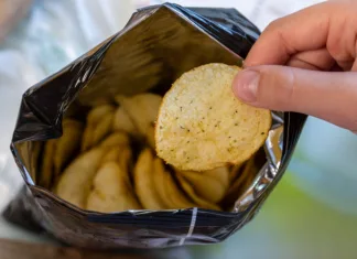 Iz treh sestavin nastane prigrizek, ki je obnorel internet Crispy potato chips in aluminum metal bag package. The concept of an unhealthy food and lifestyle. Bag of Potato Chips