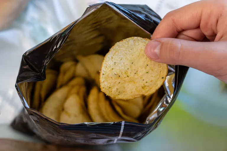 Crispy potato chips in aluminum metal bag package. The concept of an unhealthy food and lifestyle. Bag of Potato Chips