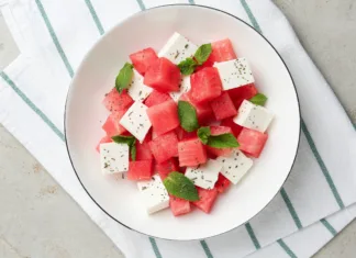 Hit poletja 2026: Pripravite osvežilen lubenični prigrizek, ki je pripravljen v le 5 minutah Delicious watermelon salad with mint and feta cheese in bowl on grey textured table, top view