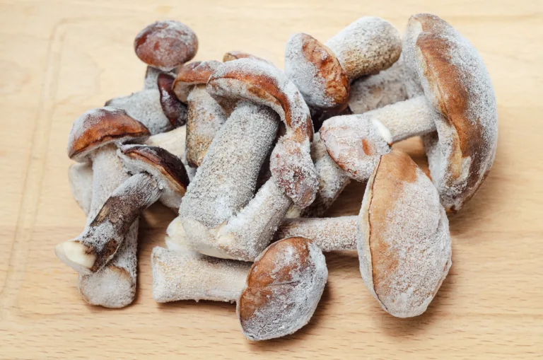 Frozen edible mushrooms lie on a cutting Board. Delicious boletus for cooking