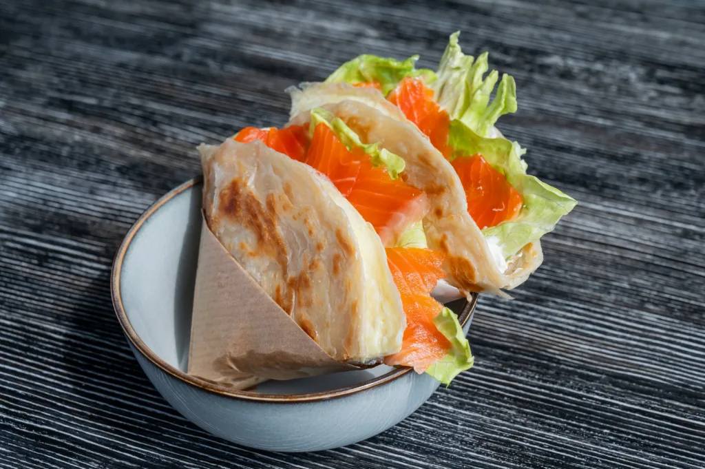 Homemade salmon flatbread on a table in a cafe