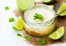 Brez peke, pripravljeno v 20 minutah: poletna sladica, ki navduši vsakogar Mini lime cheesecake in a glass pot on white wooden background