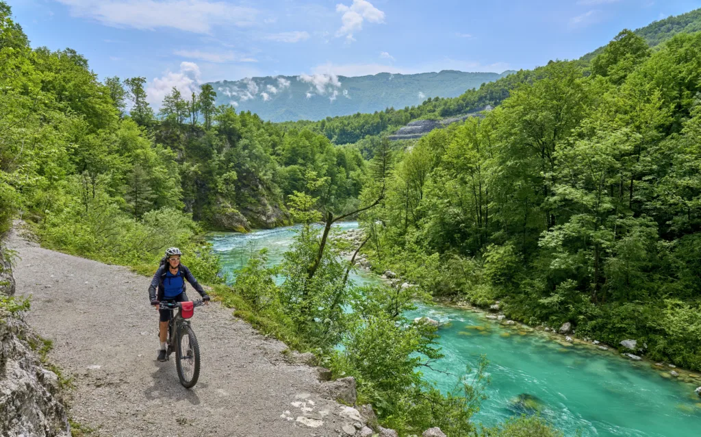 nice senior woman on a bike tour along River Soca with her electric mountain bike in the Triglav National Park in Slovenia