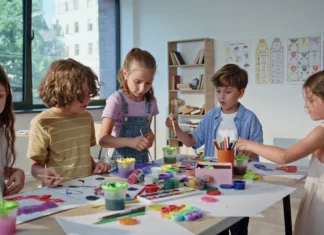Najbolj ustvarjalne sobote za otroke? Klub Cukrastičnih znova odpira vrata Pupils creating colorful art at collaborative workshop with vibrant materials. Boys girls working on painting projects at lesson classroom. Children concentrating on teamwork enjoying creativity.