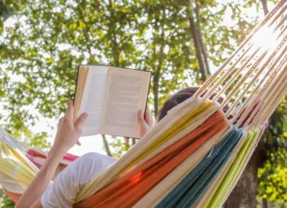 5 vrhunskih trilerjev, ki vam bodo popestrili poletno branje reading at dusk in the hammock with the open book