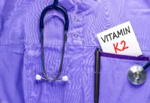 Ta vitamin ostaja v senci drugih: njegove naloge v telesu so presenetljivo pomembne Vitamin K2 phylloquinone symbol. Concept words Vitamin K2 on beautiful white card. Stethoscope and pen. Beautiful medical uniform. Medical healthy lifestyle Vitamin K2 phylloquinone concept.