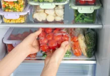 Kako pravilno shranjevati hrano v hladilniku, zamrzovalniku in shrambi Woman taking plastic bag with frozen tomatoes from refrigerator, closeup