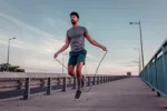 Young man jumping rope outside