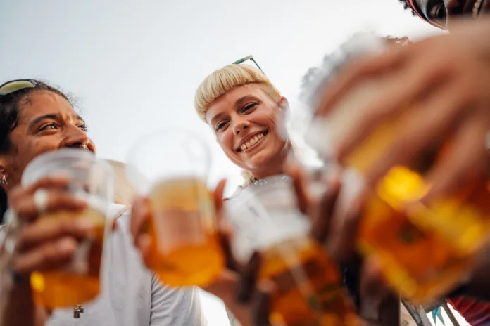 young-people-holding-plastic-beer-glasses-cheering-and-smiling-while-enjoying-a-lively-music-festival-under-a-bright-sunny-sky-celebrating-friendship-and-togetherness-stockpack-istock Pivo in cvetje 2026