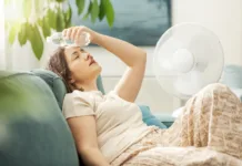 To so najboljši skriti kotički Ljubljane za pobeg pred poletno vročino Young woman sitting on the couch at home and keeping a fresh water bottle on her forehead, she is suffering from the heat