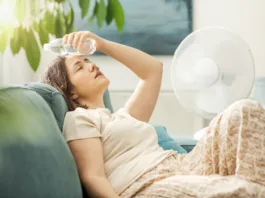 To so najboljši skriti kotički Ljubljane za pobeg pred poletno vročino Young woman sitting on the couch at home and keeping a fresh water bottle on her forehead, she is suffering from the heat