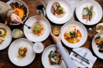 A bird's-eye view showcases a bountiful spread of delicious dishes and beverages on a rustic wooden table, ideal for food blogs, restaurant promotions, or lifestyle content.