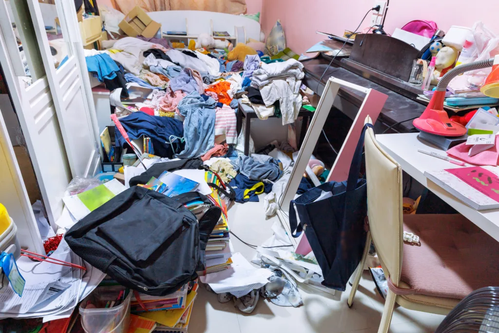 A room cluttered with piles of clothes