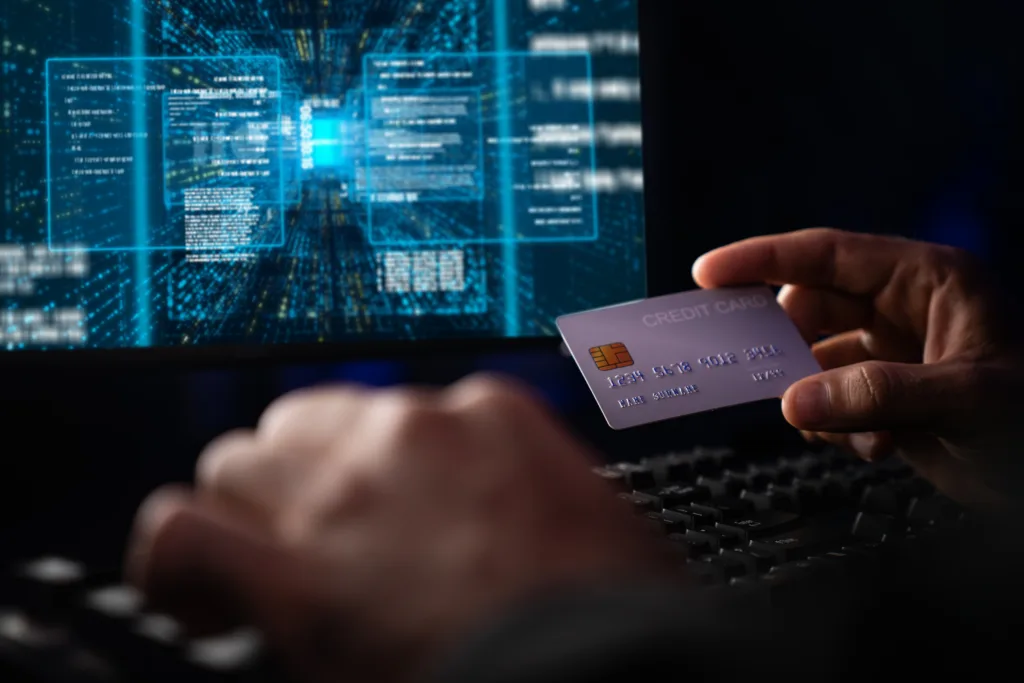 Cropped hands image in criminal anonymous male approaching credit card of personal information database for codding encryption scam program in privacy system at night at blue neon light room. Surmise.