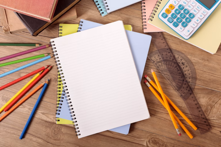 Student's desk with open notebook, text books, various pencils and calculator.  Alternative version shown below: