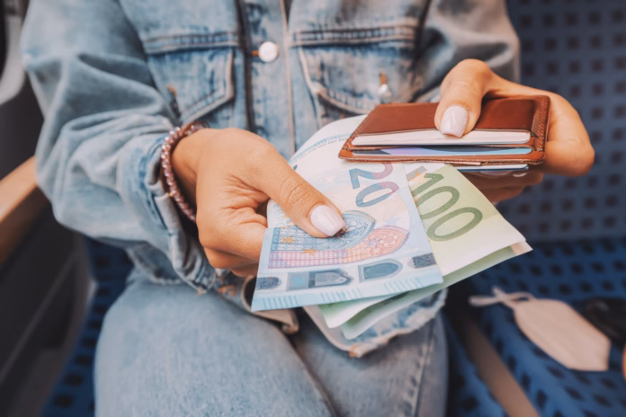 the-girl-takes-euro-banknotes-out-of-her-wallet-the-concept-of-devaluation-and-inflation-of-the-european-currency-stockpack-istock The girl takes euro banknotes out of her wallet. The concept of devaluation and inflation of the European currency