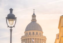 Zakaj je Francija v Panthéon pripeljala zgodovinarja, ki je svaril pred slepoto elit? The Pantheon in Paris bathed in the warm glow of a setting sun, with street lamps and a clear sky. Paris, France