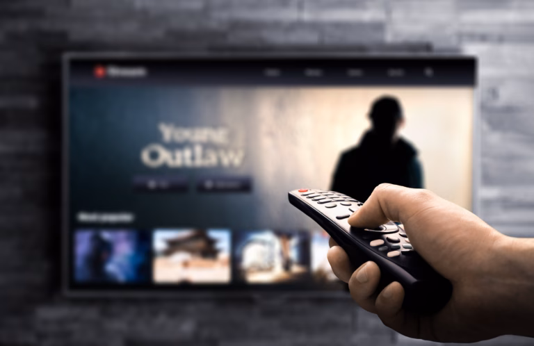 Tv stream home. Watching true crime movie or series on television screen at night. Remote in hand pov. Video platform mockup. Streaming platform content. Imaginary VOD catalogue.