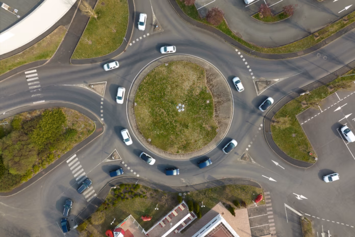 aerial-view-of-road-roundabout-intersection-with-fast-moving-heavy-traffic-urban-circular-transportation-crossroads-stockpack-istock Aerial view of road roundabout intersection with fast moving heavy traffic. Urban circular transportation crossroads.