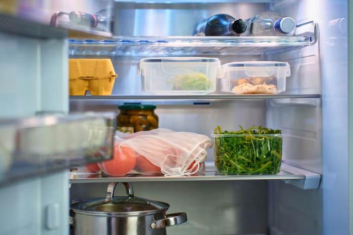 inside-view-of-open-refrigerator-with-containers-of-food-fresh-greens-tomatoes-and-kitchen-items-on-shelves-concept-of-healthy-diet-and-food-storage-stockpack-istock Inside view of open refrigerator with containers of food, fresh greens, tomatoes and kitchen items on shelves. Concept of healthy diet and food storage