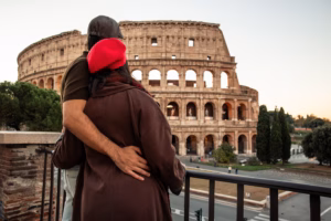 Loving couple looking out at the ancient Colosseum in Rome, Italy, sharing a tender embrace on their travel adventure, symbolizing romance and historical exploration
