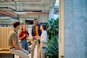 Multicultural businesspeople talking and smiling during a meeting in a modern office with plants