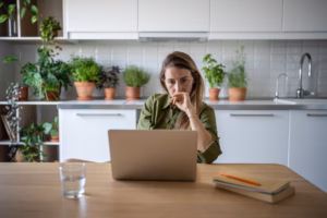 Thoughtful serious woman freelancer working from home look at screen of laptop. Busy remote accountant examines financials. Frustrated female feel upset with obtained job results. Job search online.