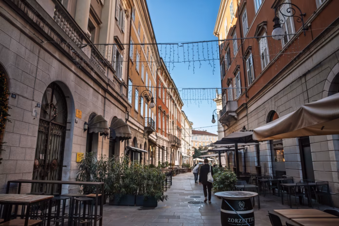 trieste-italy-december-27-2024-scenic-view-of-a-lively-street-in-the-historic-city-center-of-trieste-italy-lined-with-inviting-cafes-and-restaurants-this-pedestrian-street-showcases-the-vibrant-daily--stockpack-istock Trieste, Italy - December 27, 2024: Scenic view of a lively street in the historic city center of Trieste, Italy, lined with inviting cafes and restaurants. This pedestrian street showcases the vibrant daily life and cultural atmosphere of the city, featuring outdoor seating, historical European architecture, and the bustling social activities typical of Italian urban life.