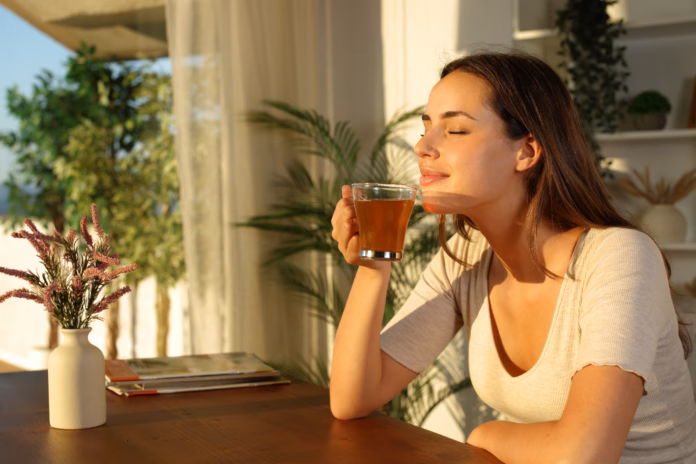 woman-at-home-relaxing-smelling-tea-at-sunset-stockpack-istock Woman at home relaxing smelling tea at sunset