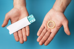 Male contraceptives. Pills and condom in hands of men